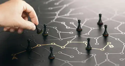 A person moving a pawn on a strategy board